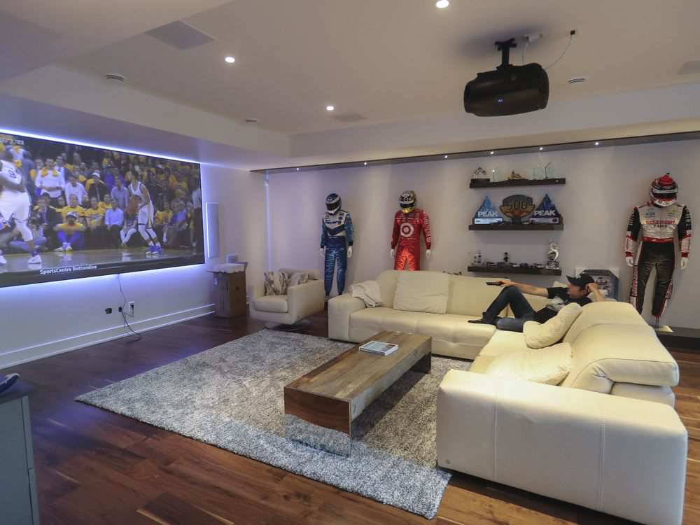 Race car driver Alex Tagliani watches television in his home in Lorraine. The home, which was moved into less than a week ago, is fully decked out with smart devices. (John Kenney / Montreal Gazette)